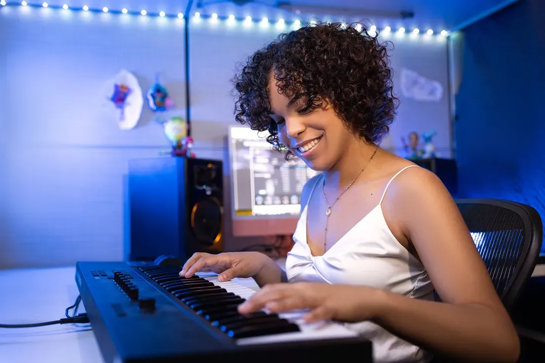 Student sitting at a table playing a keyboard.